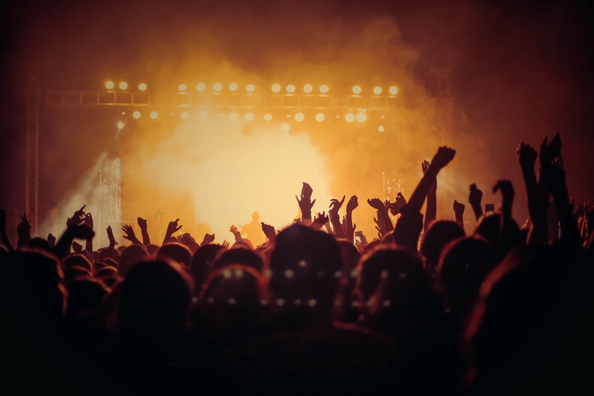 Crowd at a live concert with bright stage lighting