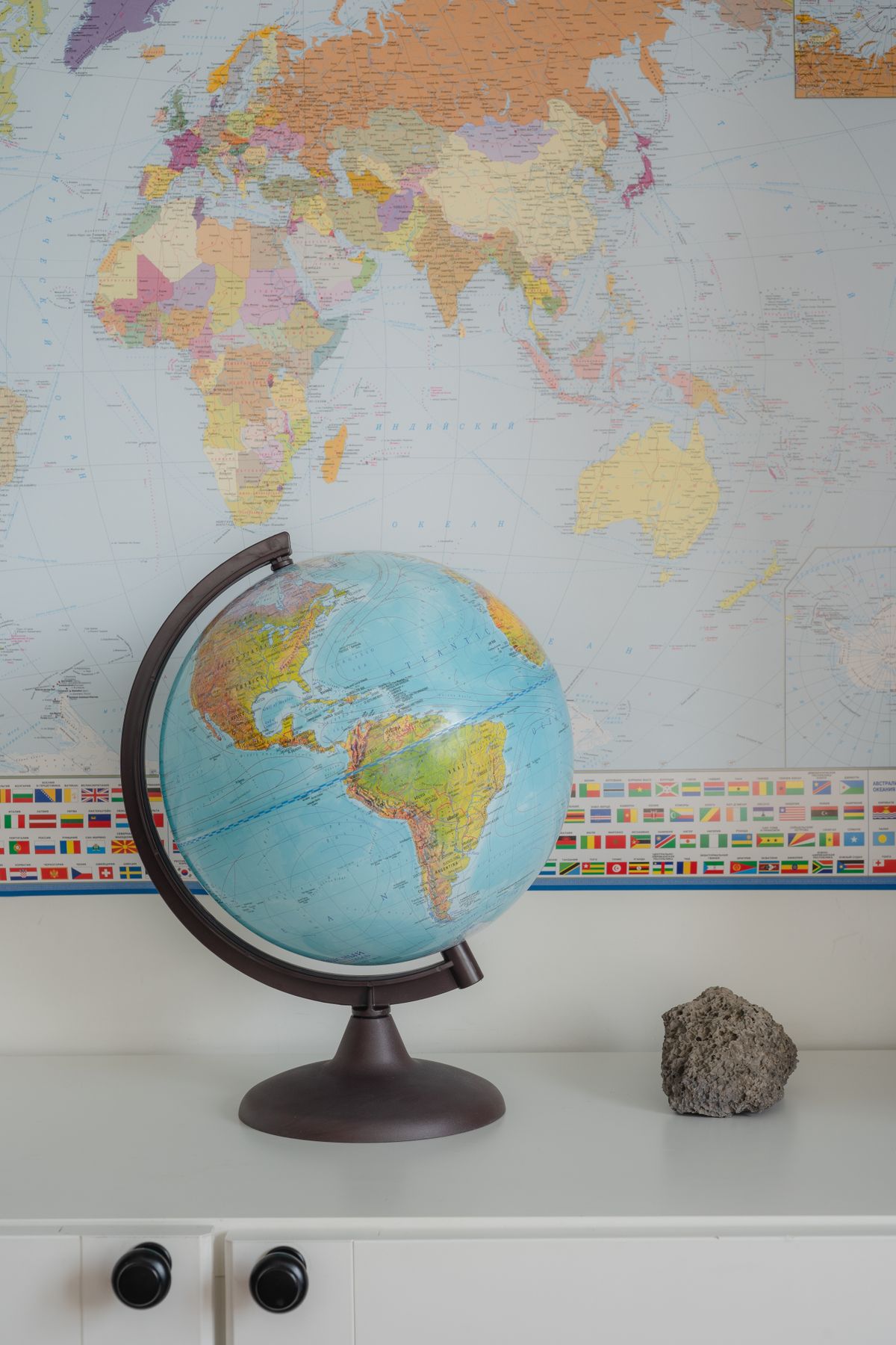 Desk globe in front of a colourful world map