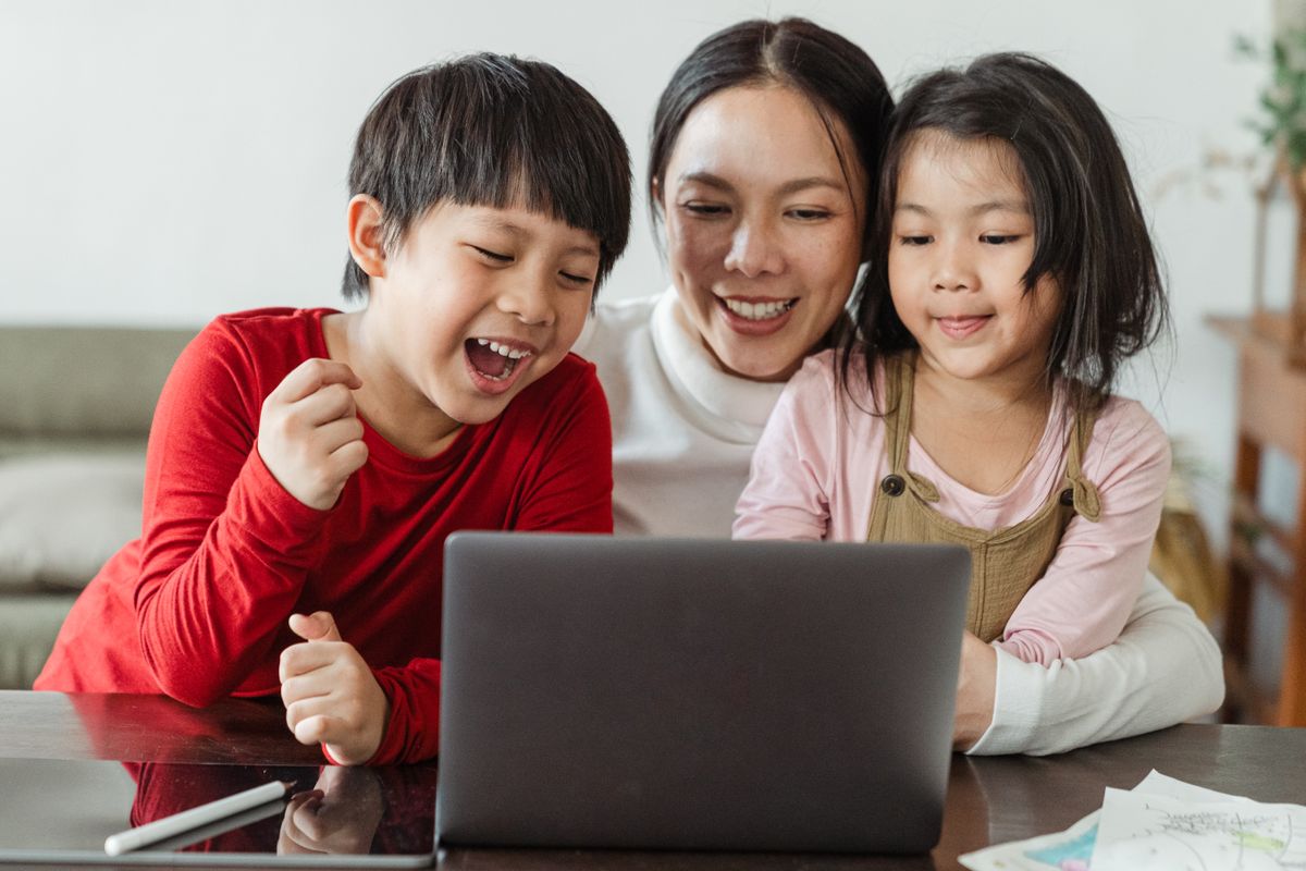 Parent and children watching a cartoon together at home
