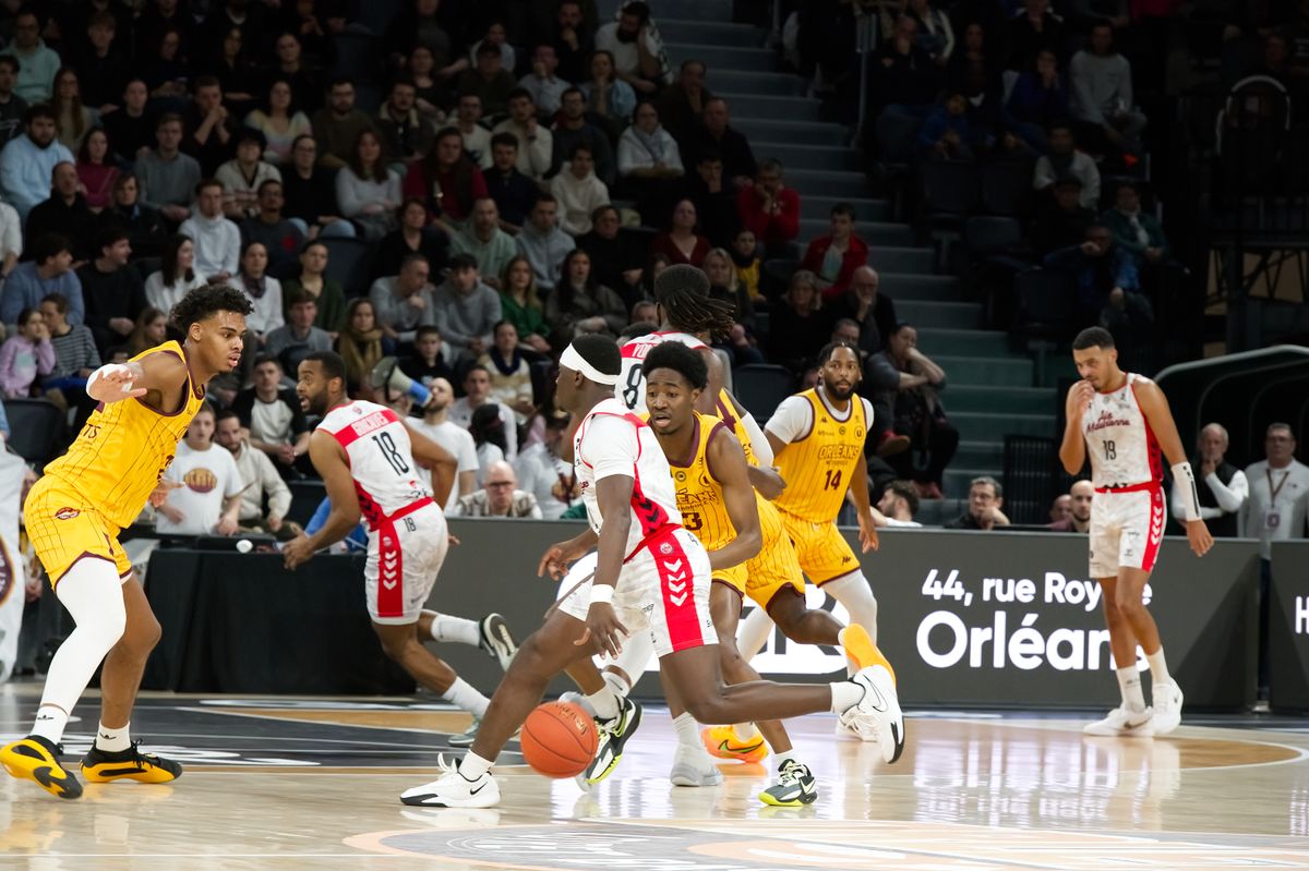 Basketball players competing during an indoor arena game