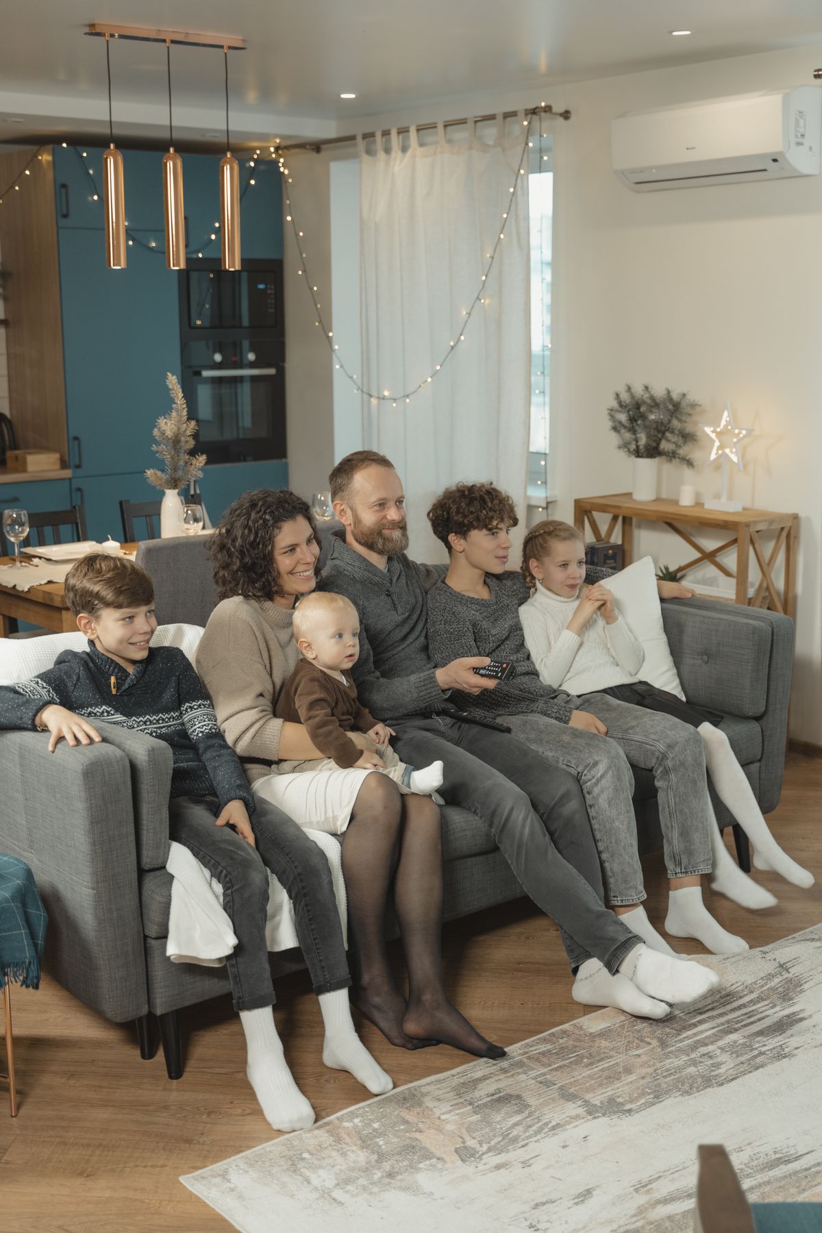 Family sitting together on a sofa watching television at home