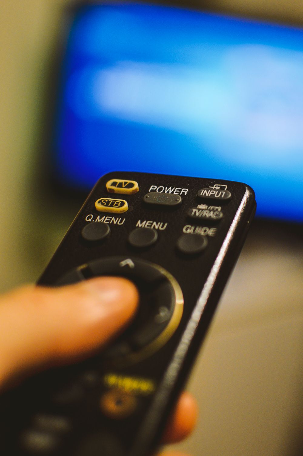 Person holding a remote controller while watching television
