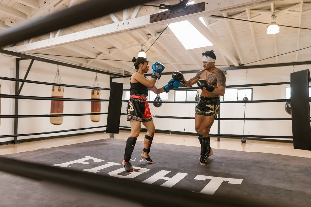 Two boxers training in a ring wearing gloves