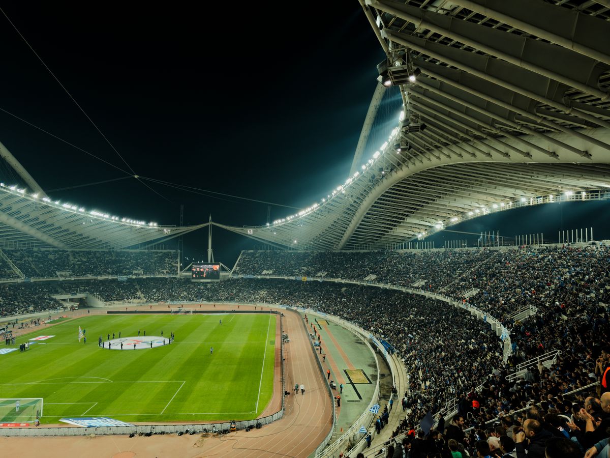 Illuminated soccer stadium at night packed with supporters